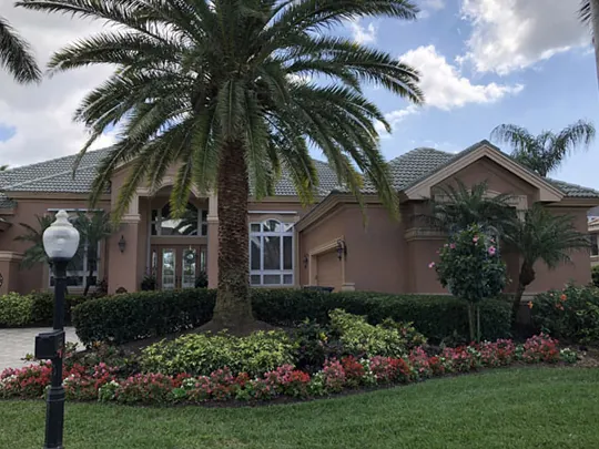 Landscaped Florida home with tropical flower beds and palms